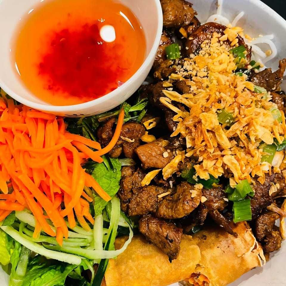 Pho Boca's Vietnamese vermicelli bowl with grilled beef, egg roll, fresh vegetables, and dipping sauce.