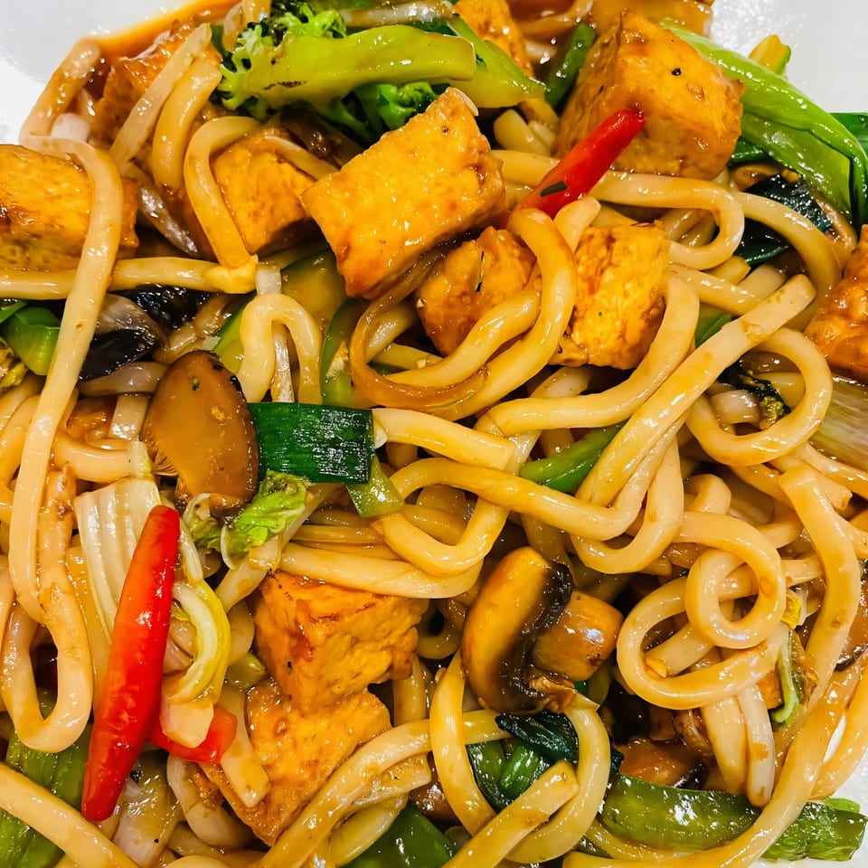 Close-up of Pho Boca's Vietnamese stir-fried noodles with tofu, broccoli, mushrooms, and red chili.